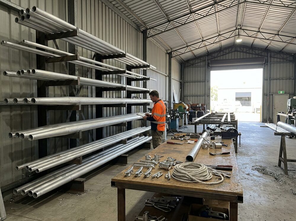 Aluminium flagpoles racked in the factory while an order is checked