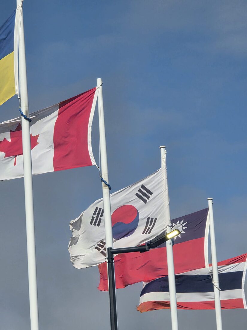 International flags including Canada and South Korea flying together